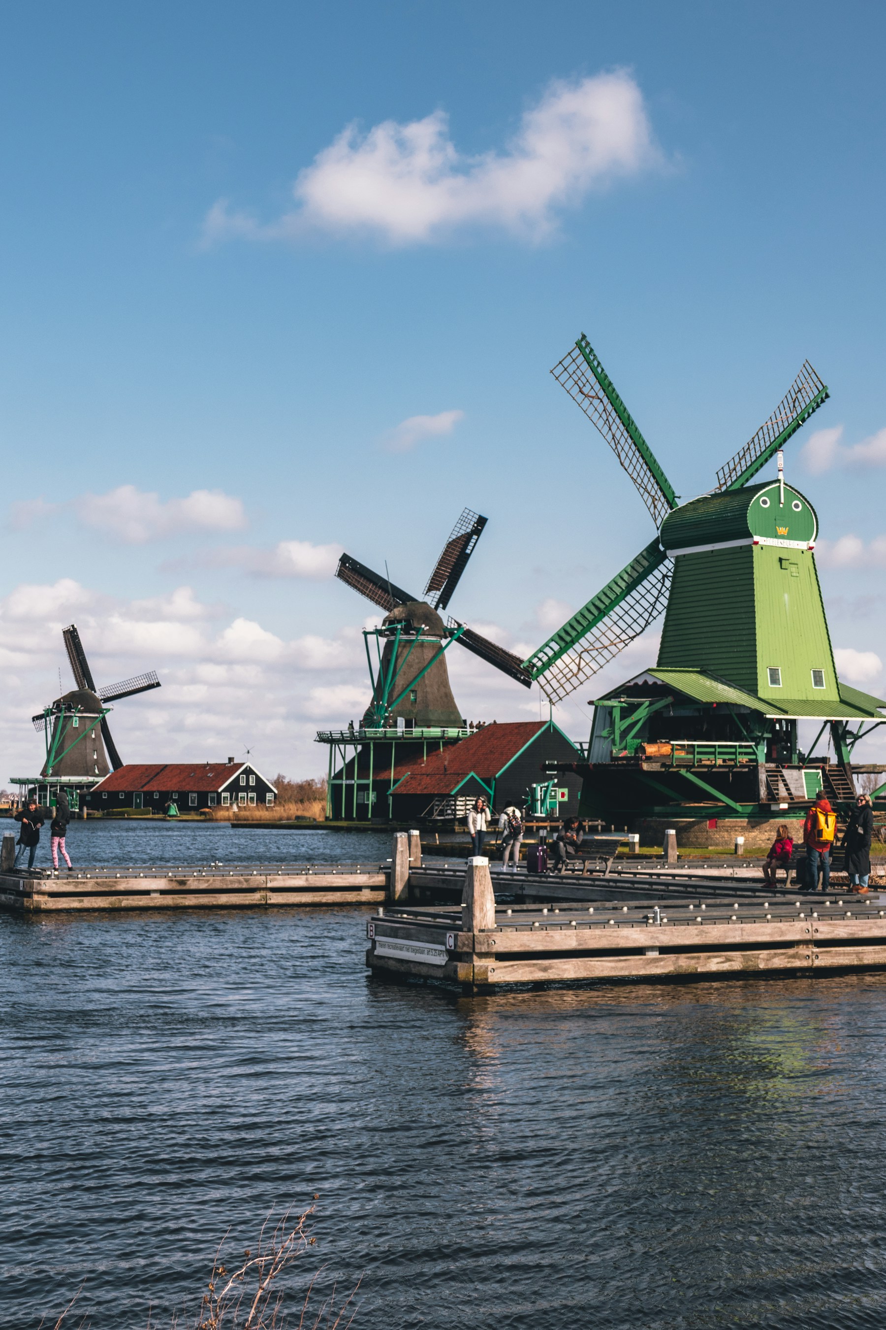 Groene houten molens aan het water op de Zaanse Schans